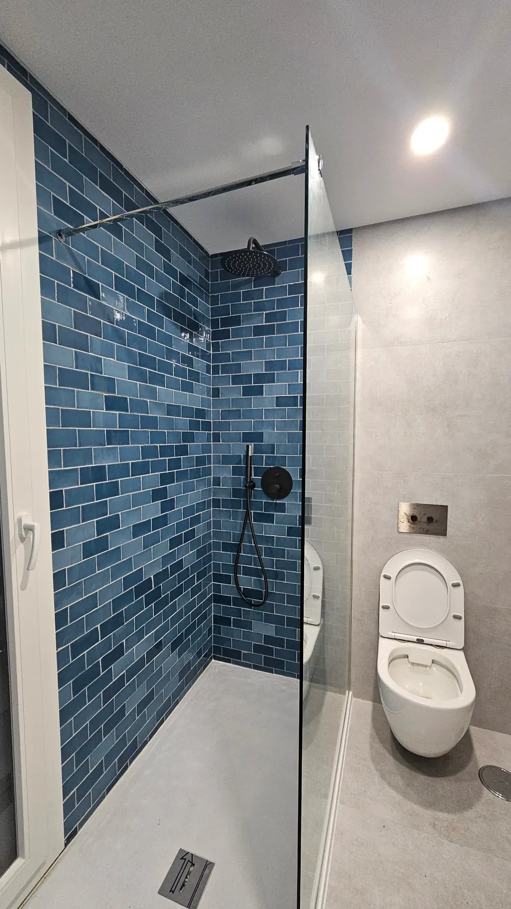 Duche com revestimento azul e resguardo
